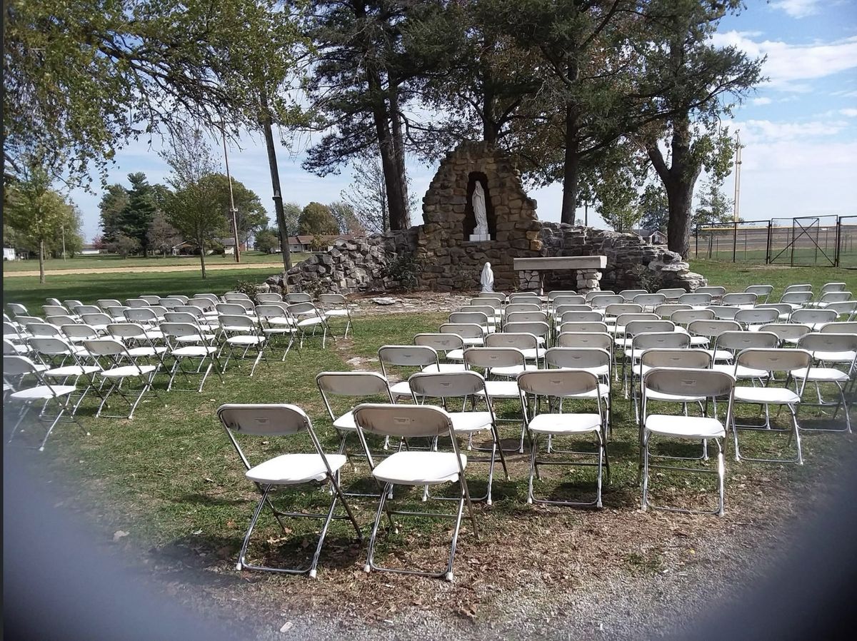 Rows of basic white folding chairs set up for an outdoor church service